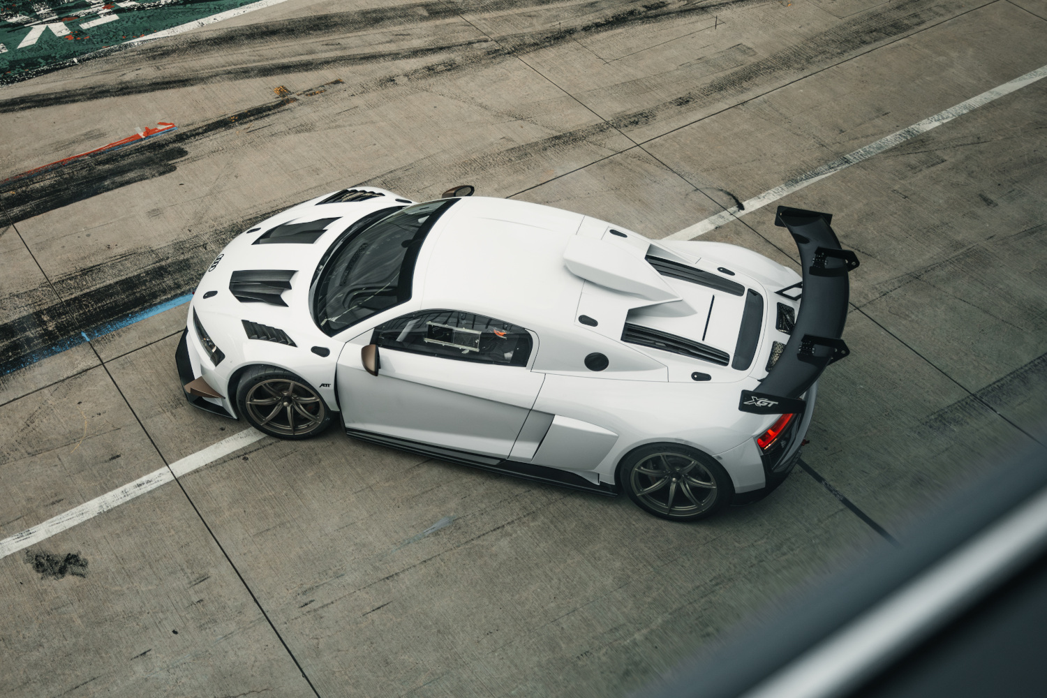 Black and white XGT from the side bird's eye view on the race track 