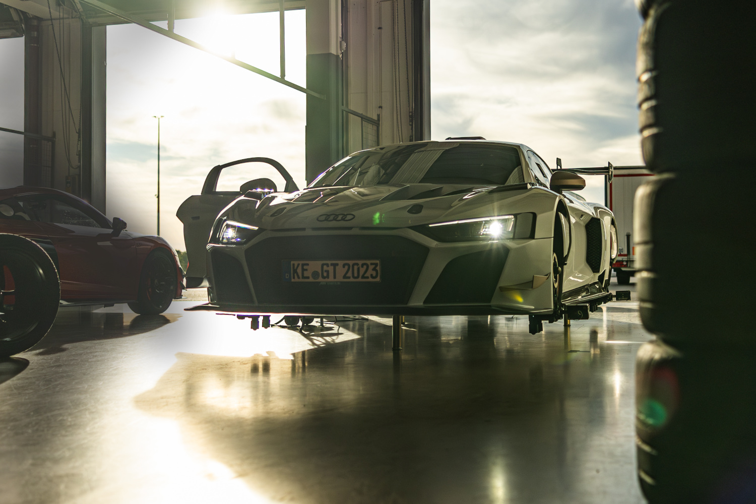 Black and white XGT with illuminated lights on lifting platform in box from the side front view 