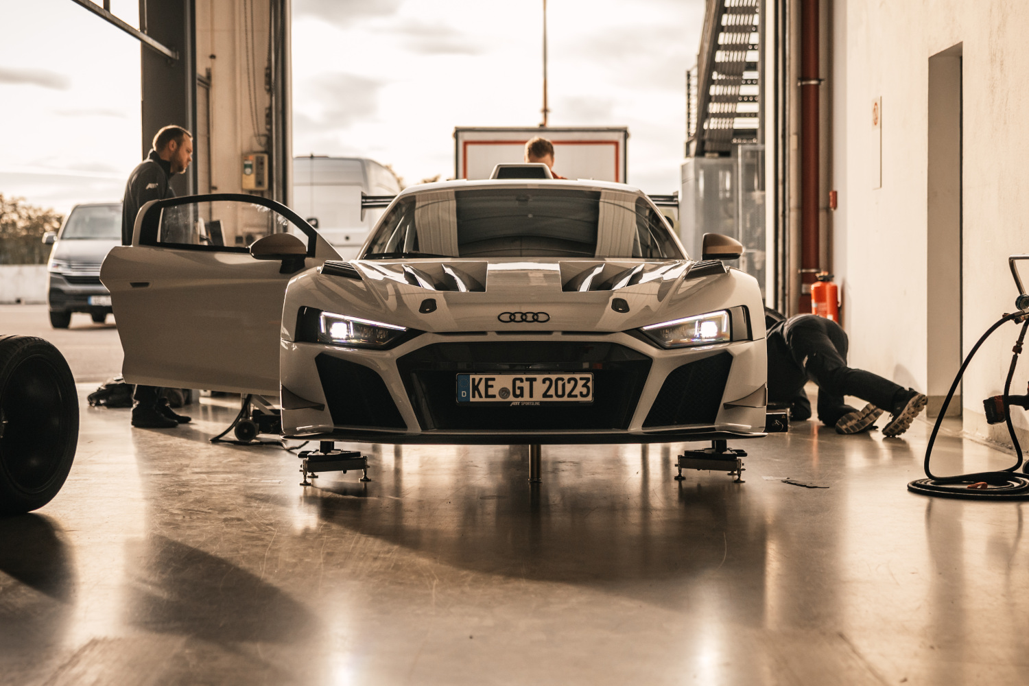 Black and white XGT from the front view on a lifting platform while changing tyres in the box 