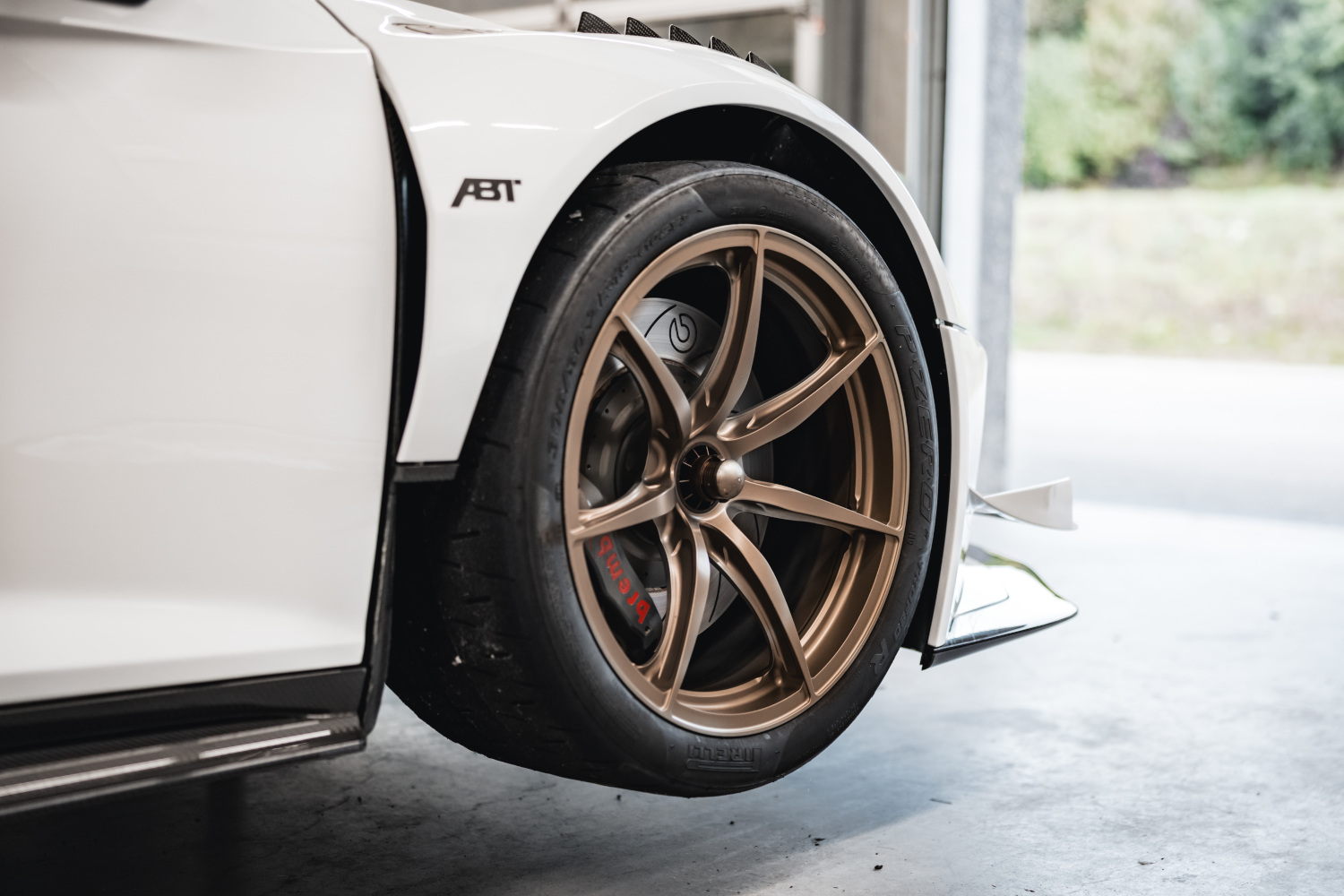 Close-up of bronze-coloured wheel on lifting platform of black and white XGT