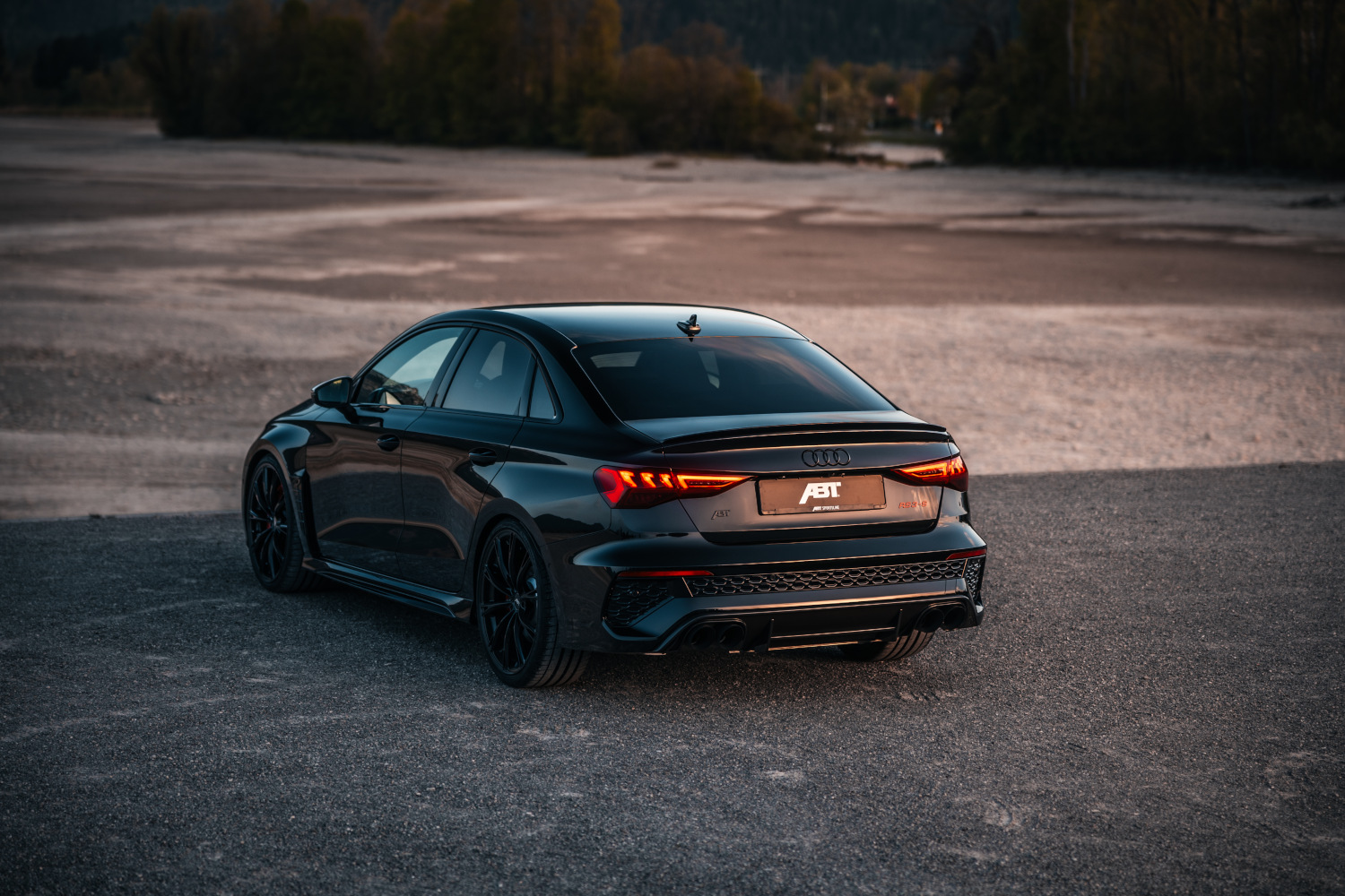 Black RS3-S from the side rear view in front of the forest