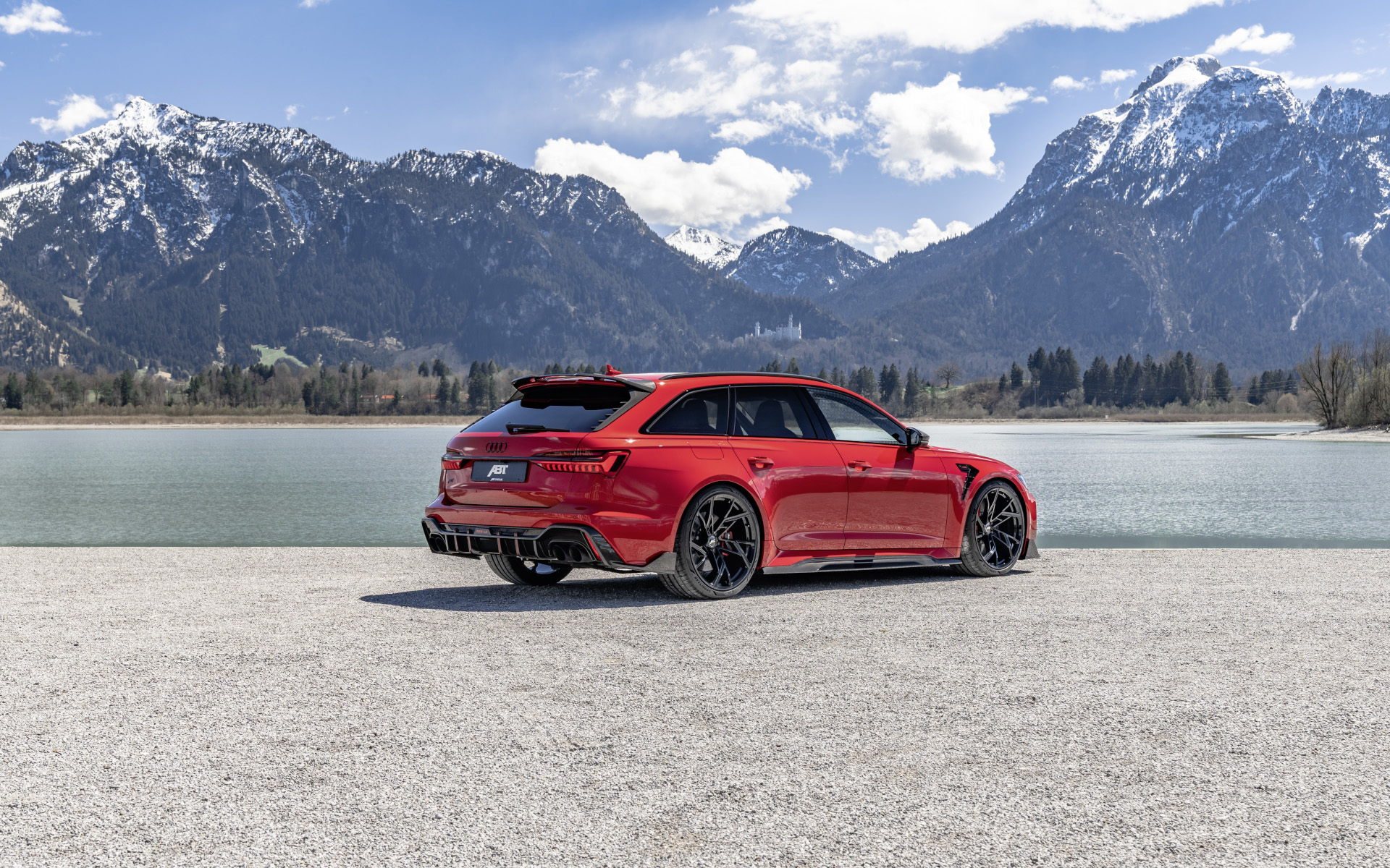 Red RS6-LE from the side rear perspective in front of lake with mountain panorama