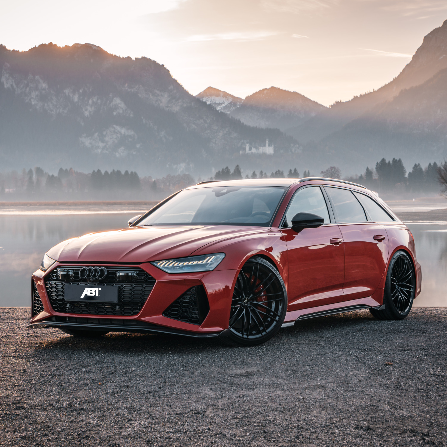 Red RS6-S from the side rear view in front of lake with mountain panorama