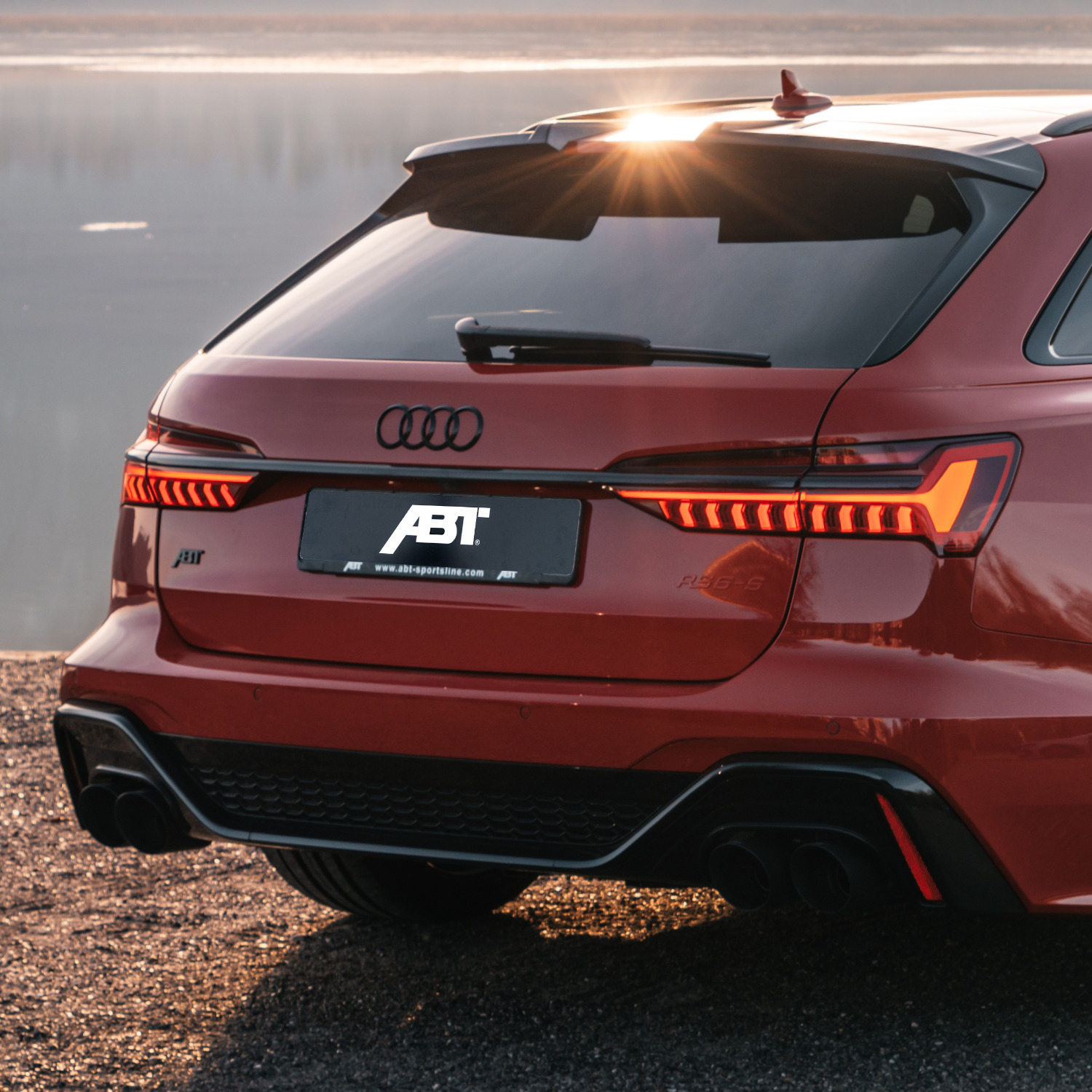 Red RS6-S from the side rear view in front of the sea