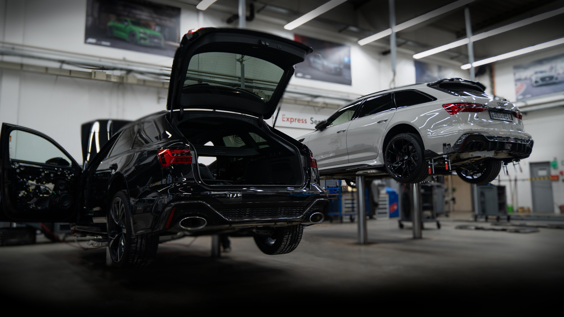 View of two jacked-up vehicles in the workshop