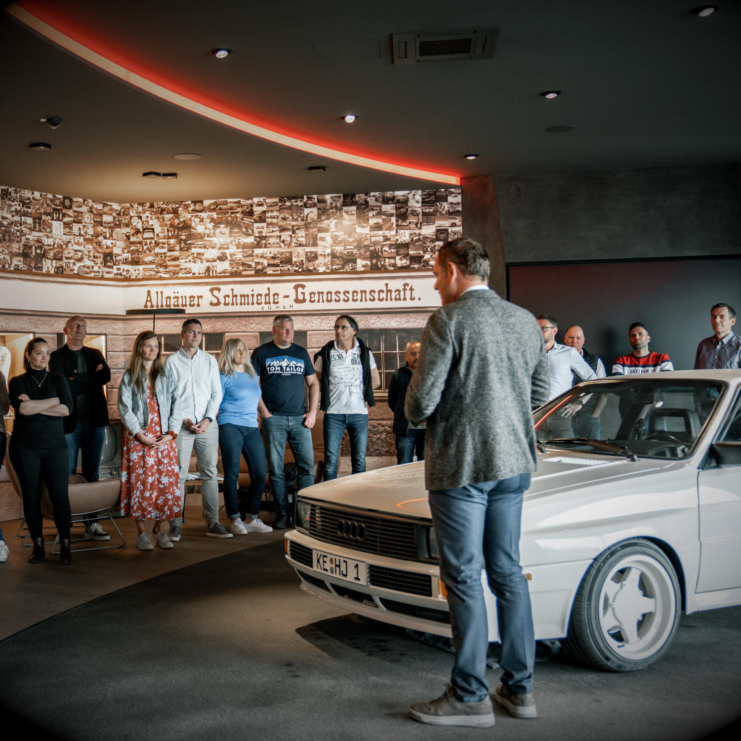 Hans-Jürgen Abt stands next to the original Quattro in the noble forge and gives a lecture