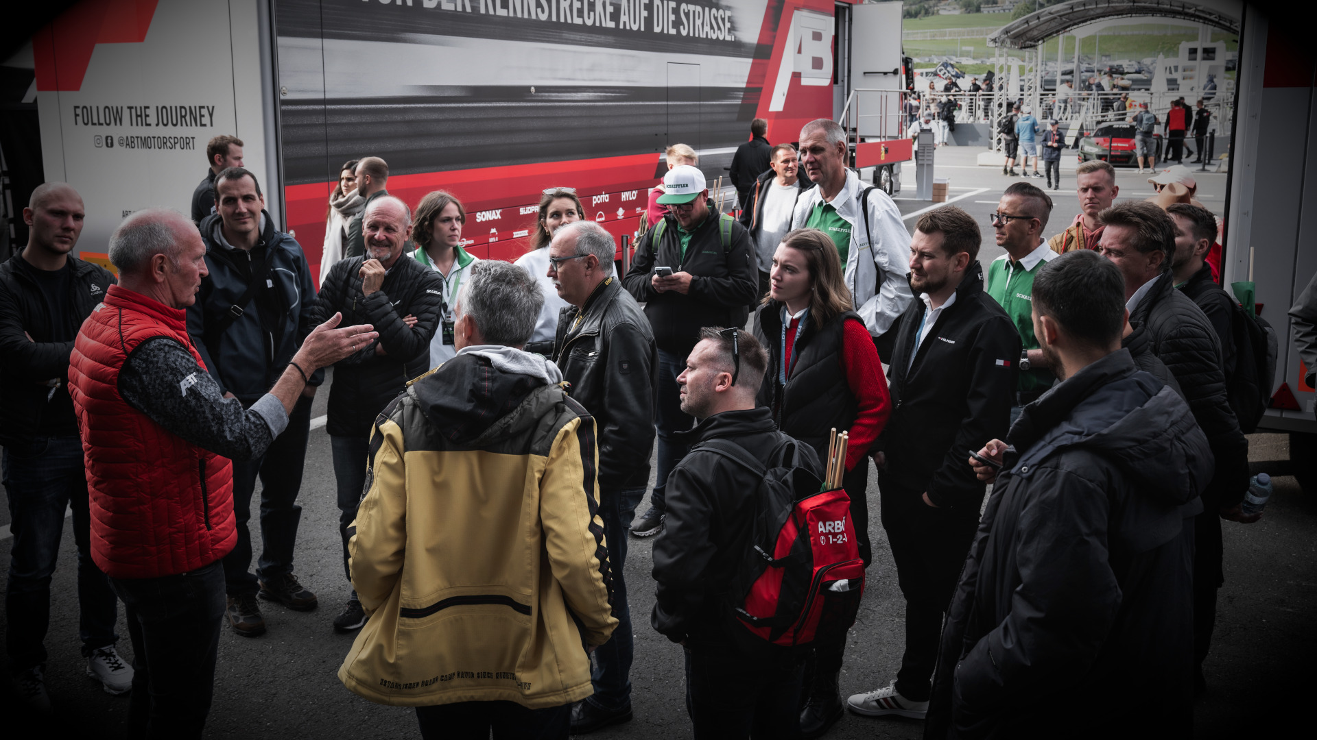 Harry Unflath with a group of fans & partners in front of an ABT Motorsport lorry